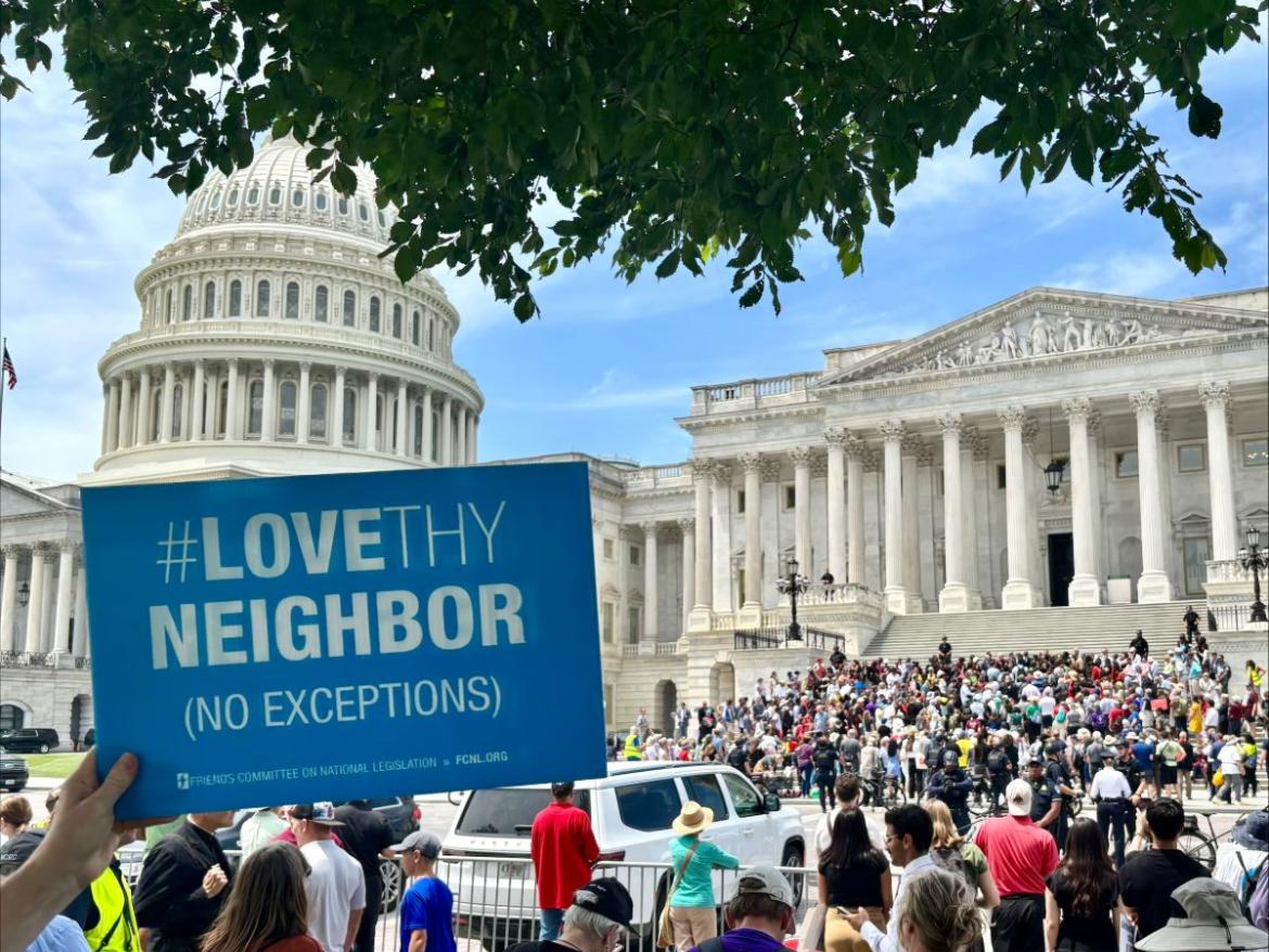 Love thy neighbor sign in front of Capitol and crowd