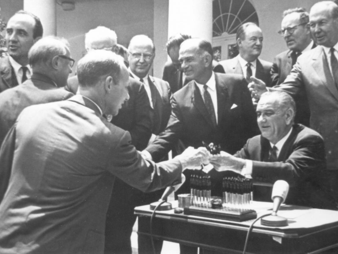 Ed Snyder receives a pen from Pres. Lyndon B. Johnson after signing the 1965 Arms Control & Disarmament Act Extension.