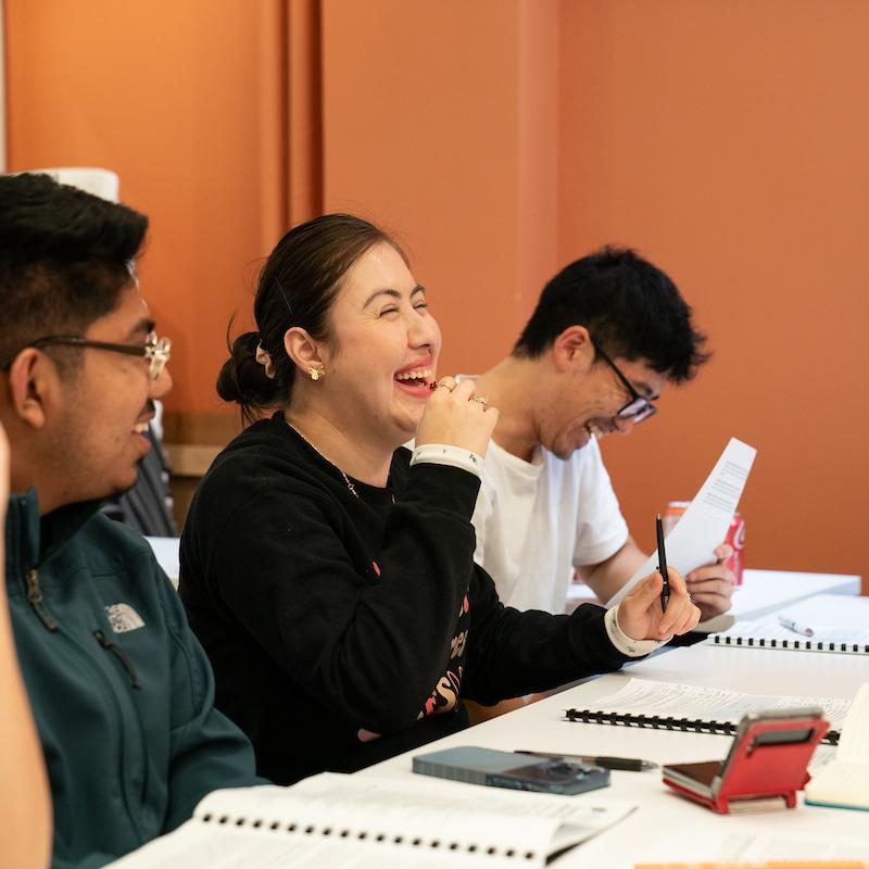 A group of young advocates sitting at a table together, laughing